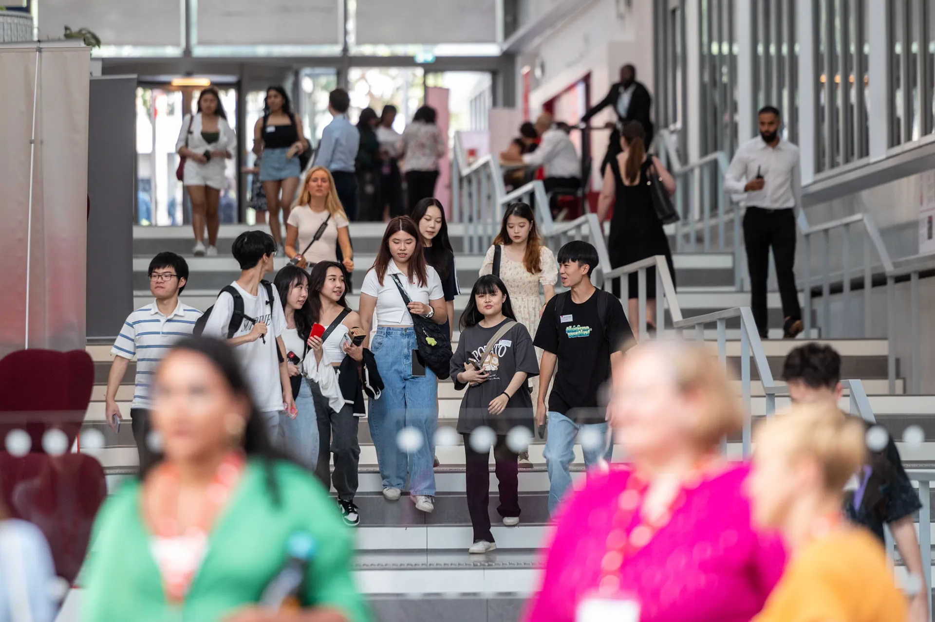 Des étudiantes et étudiants sur les escaliers de l'entrée sur Jean Jaurès, campus de Lyon - emlyon business school