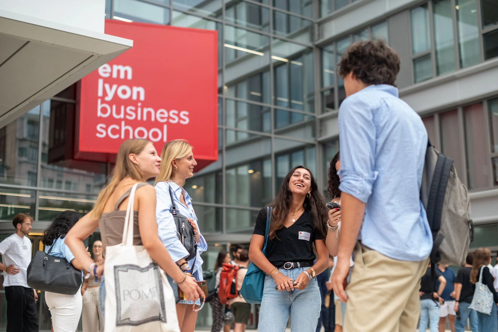 Des étudiantes et étudiants d'emlyon business school, devant l'entrée sur avenue Jean Jaurès