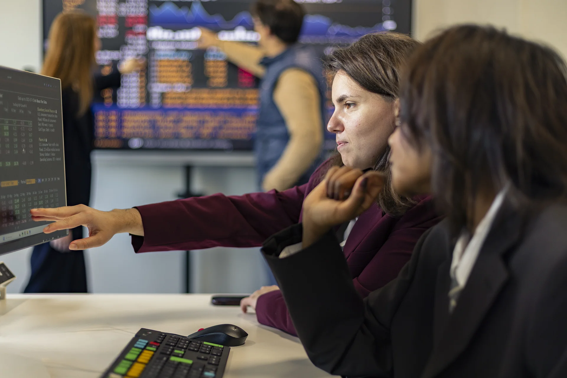 Deux collègues au bureau regardent l'écran d'un ordinateur.