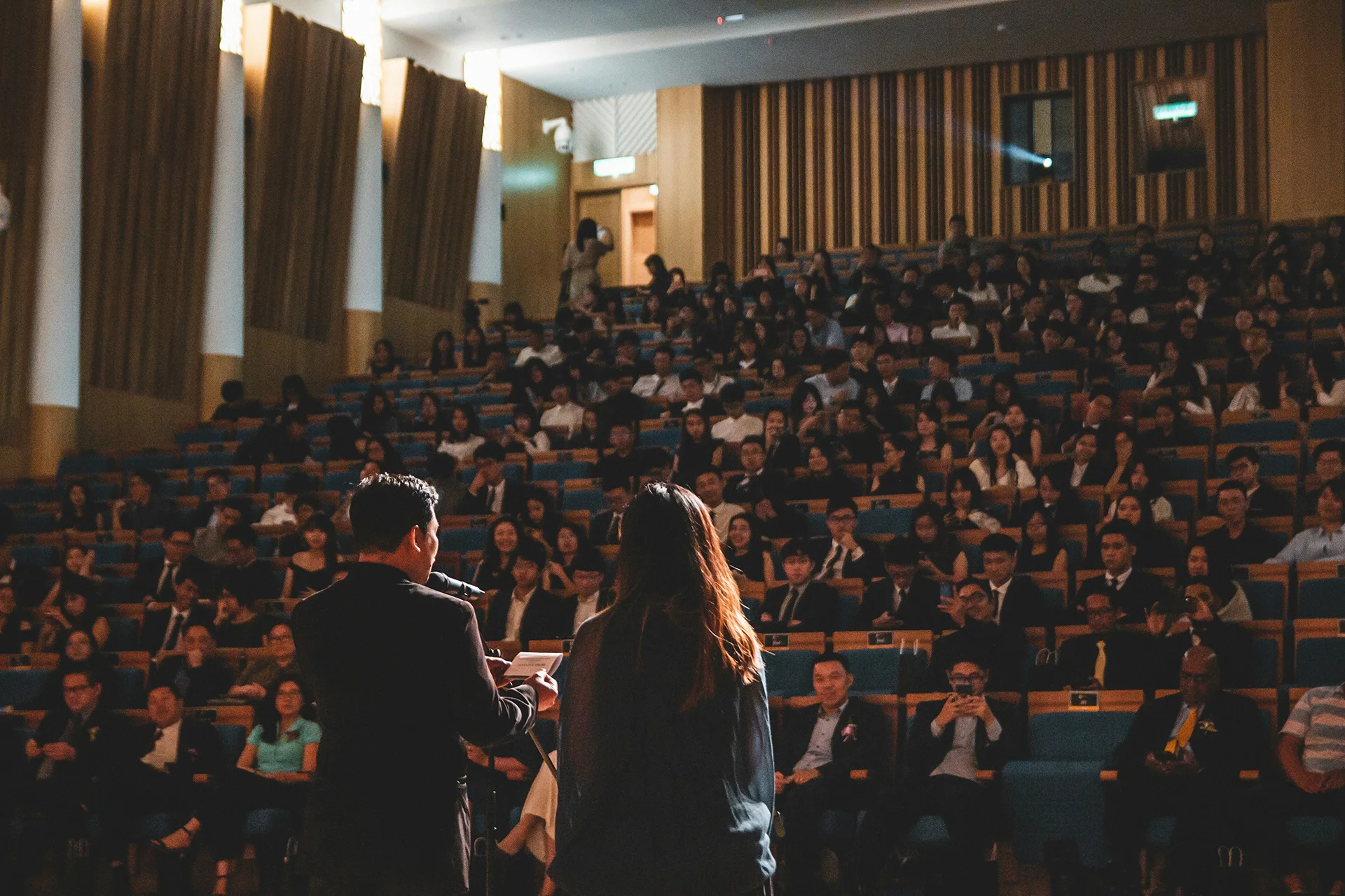 Conférence avec deux intervenants s’exprimant devant un large public dans un amphithéâtre.
