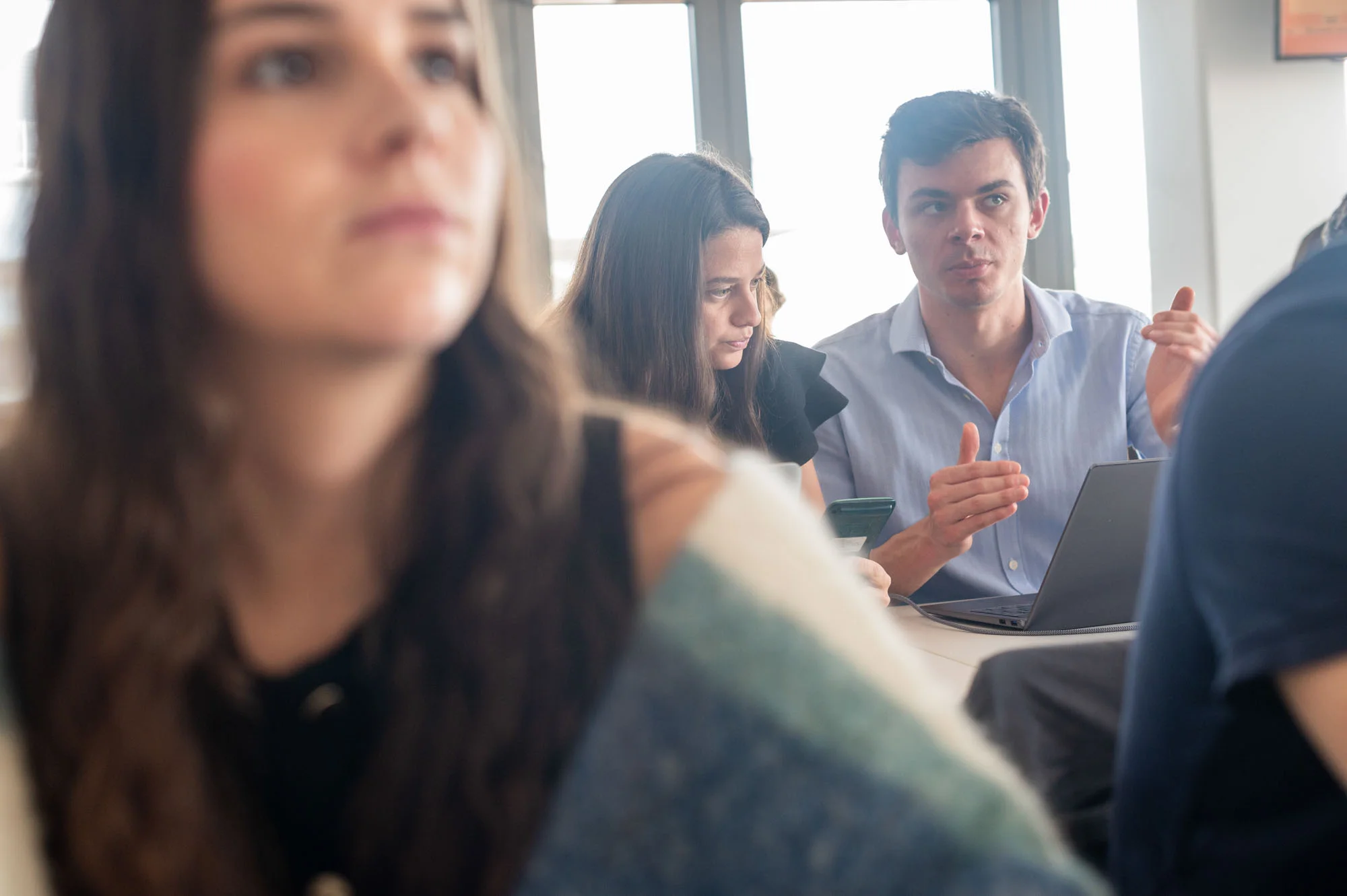 Séance de travail en groupe du programme MSc d’emlyon business school avec des étudiants échangeant autour d’un ordinateur.