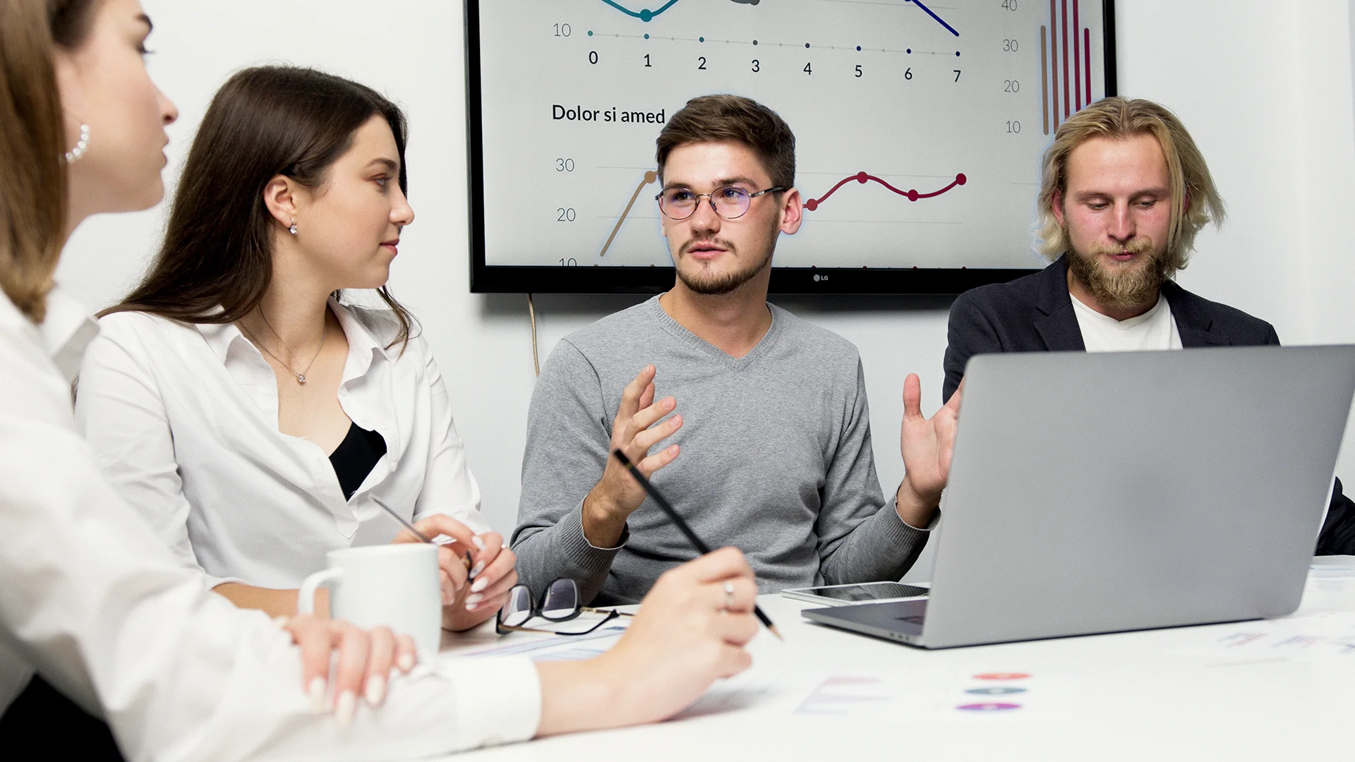 Réunion d’équipe autour d’un ordinateur avec présentation de données et graphiques lors d’un atelier de travail collaboratif.