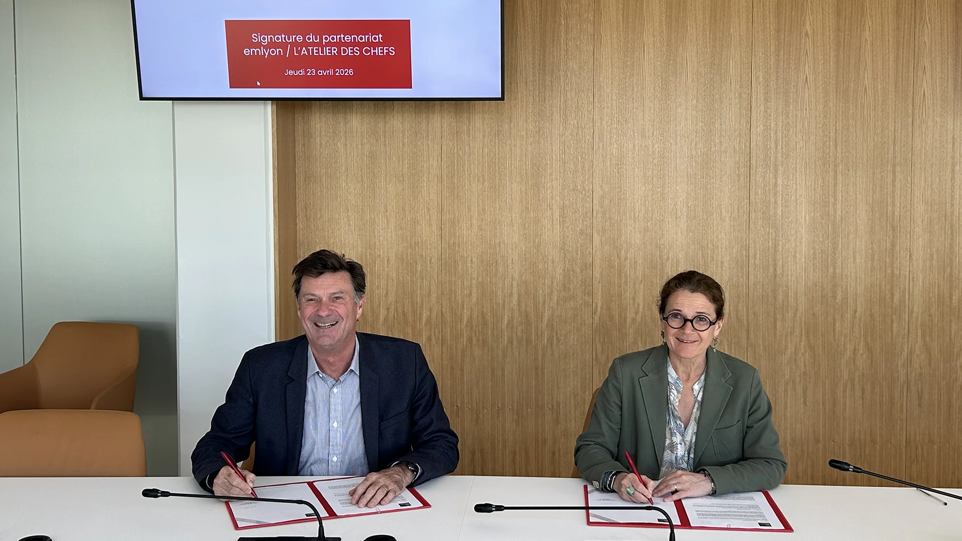 Signature du partenariat entre emlyon business school et L’atelier des Chefs lors d’une cérémonie officielle, avec deux représentantes et représentants signant les documents.