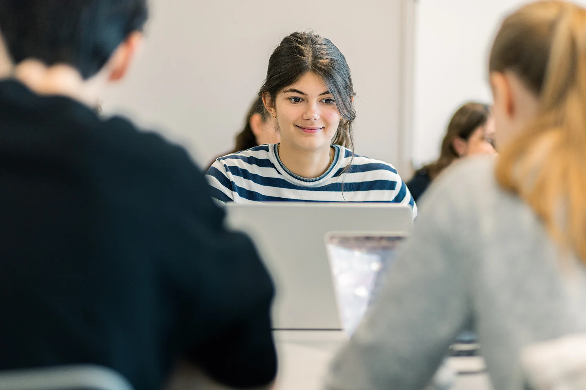Étudiantes et étudiants du Programme Grande École (Master in Management) d’emlyon, assis en salle de cours et travaillant sur des ordinateurs portables.