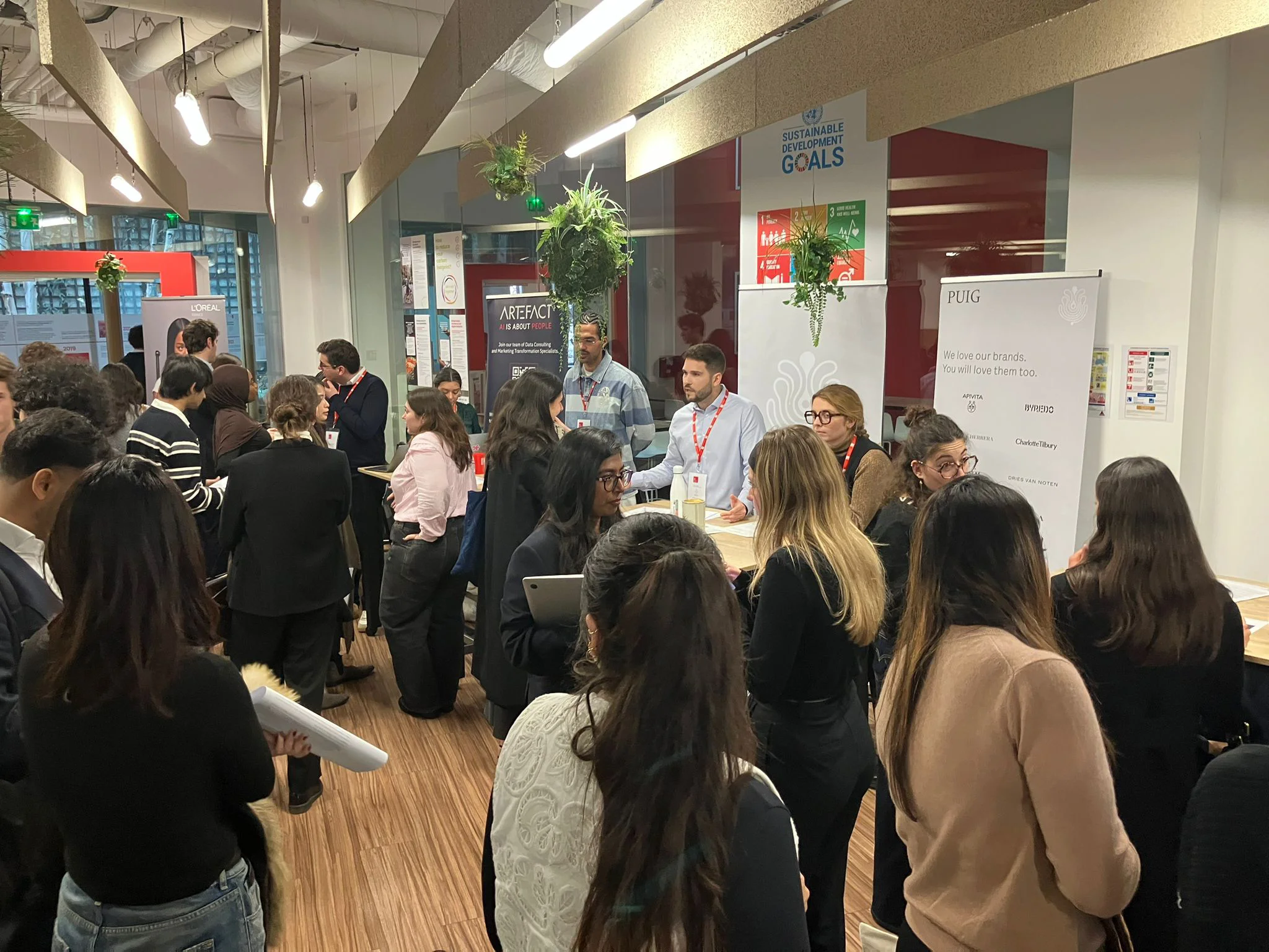 Événement WiDS au campus emlyon de Paris : participants échangent lors d’une session de networking autour de stands partenaires, février.