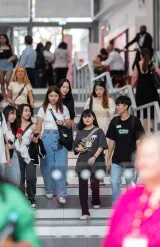 Des étudiantes et étudiants sur les escaliers de l'entrée sur Jean Jaurès, campus de Lyon - emlyon business school