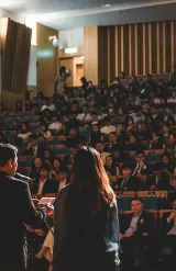 Conférence avec deux intervenants s’exprimant devant un large public dans un amphithéâtre.
