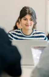 Étudiantes et étudiants du Programme Grande École (Master in Management) d’emlyon, assis en salle de cours et travaillant sur des ordinateurs portables.