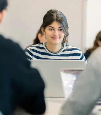 Étudiantes et étudiants du Programme Grande École (Master in Management) d’emlyon, assis en salle de cours et travaillant sur des ordinateurs portables.
