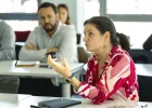 Executive MBA participant speaking during a group discussion at emlyon, with other participants seated in a classroom environment.