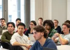 Group of students listening to a lecture with laptops in a business school classroom