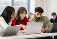 Étudiants collaborant sur des ordinateurs portables pendant un cours dans une école de commerce. Afficher plus de lignes