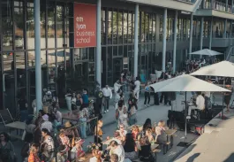 Outdoor end-of-year celebration at emlyon business school with students gathered on the campus terrace