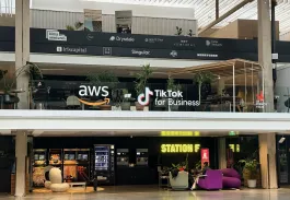 The image showcases a group of emlyon students gathered in front of a modern art installation at Station F, a renowned innovation hub in Paris. The atmosphere is vibrant and collaborative, reflecting the entrepreneurial spirit that permeates this incubator. The students share a moment of camaraderie, capturing the essence of their visit as they explore the dynamic environment filled with opportunities for creativity and networking.