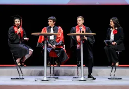 Table ronde sur scène lors d’une cérémonie de remise de diplômes avec plusieurs intervenants en toge noire et écharpe rouge.
