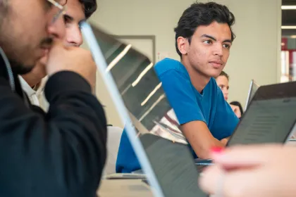 Des étudiants dans une salle de cours, échangeant entre eux.