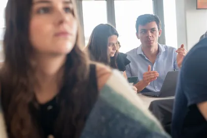 Group work session from the emlyon business school MSc program with students discussing around a laptop.