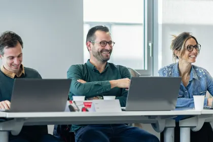 Participants of the emlyon executive program attending a training session, working together on laptops in a modern classroom