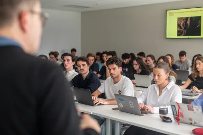 Étudiants du Global BBA d’emlyon business school suivant un cours en salle de classe et travaillant sur ordinateurs portables.