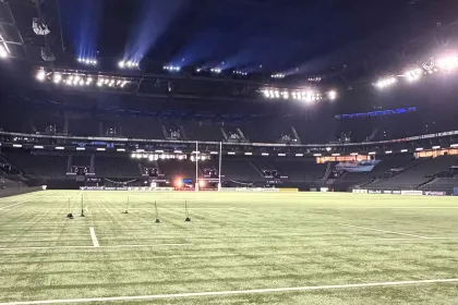 Vue panoramique du terrain et des tribunes de la Defense Arena, mettant en valeur l’infrastructure sportive moderne.