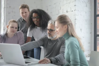 Équipe collaborant autour d’un ordinateur portable dans un bureau lumineux