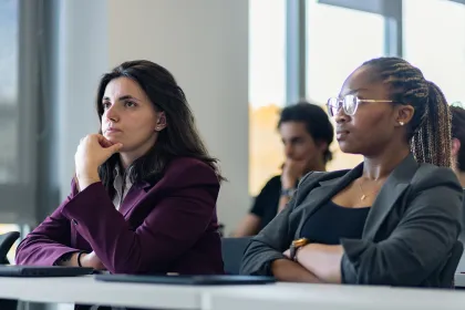 Session de formation avec un groupe d’étudiants attentifs face à une intervenante