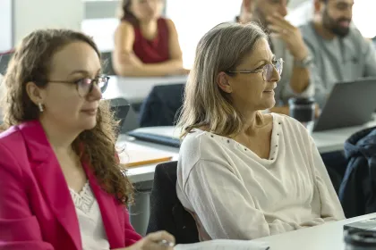 Executive MBA participants at emlyon seated in a classroom, listening attentively during a course session.