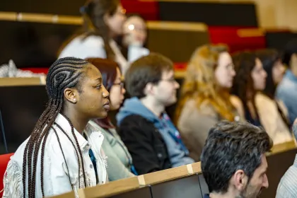 Participants à l’hackathon d’emlyon business school assis dans l'amphithéâtre du campus de Lyon, attentifs pendant une session de travail collaborative.
