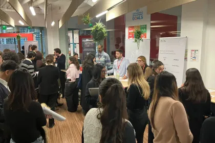 WiDS event at emlyon Paris campus: attendees networking around partner booths during an indoor session, February.