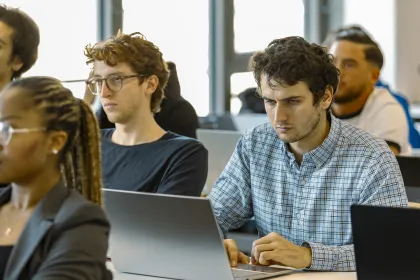 Étudiants travaillant sur leurs ordinateurs portables lors d’un cours de finance en salle de classe à emlyon business school.