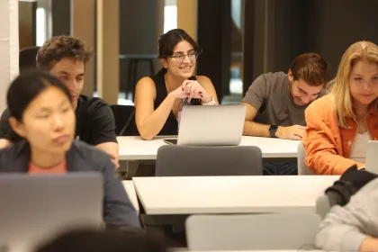 Students working on laptops during a collaborative learning session in a modern classroom