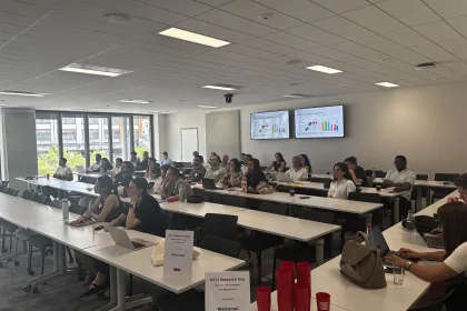 Participants assistent à une session du MTCI Research Day dans une salle de conférence d’emlyon business school, avec présentations projetées sur des écrans et ordinateurs portables sur les tables.