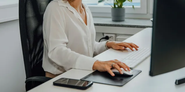 Une femme au bureau, devant l'ordinateur Une femme au bureau, devant l'ordinateur