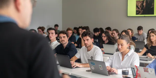 Étudiants du Global BBA d’emlyon business school suivant un cours en salle de classe et travaillant sur ordinateurs portables.