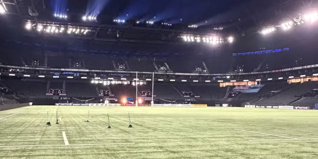 Vue panoramique du terrain et des tribunes de la Defense Arena, mettant en valeur l’infrastructure sportive moderne.
