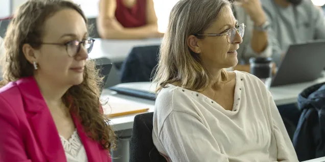 Executive MBA participants at emlyon seated in a classroom, listening attentively during a course session.