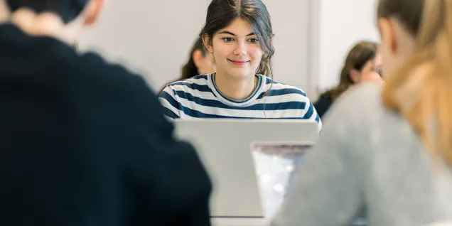 Programme Grande École (Master in Management) students at emlyon seated in a classroom, working on laptops.