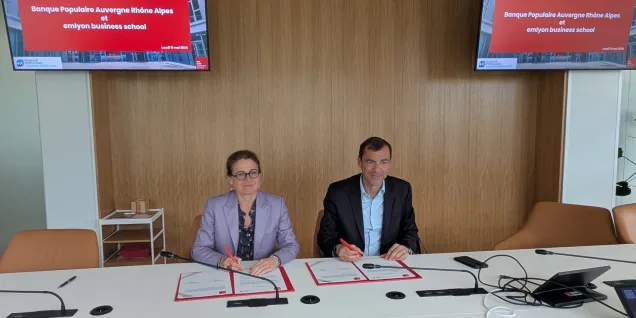 Isabelle HUALT and Daniel KARYOTIS  standing in front of partnership announcement screen