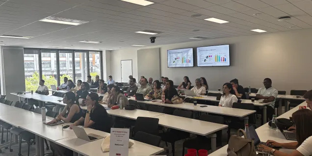 Participants assistent à une session du MTCI Research Day dans une salle de conférence d’emlyon business school, avec présentations projetées sur des écrans et ordinateurs portables sur les tables.