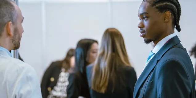 Participants échangeant lors d’un forum carrières, d’un événement de recrutement ou d’une rencontre professionnelle favorisant le développement du réseau et des opportunités de carrière.