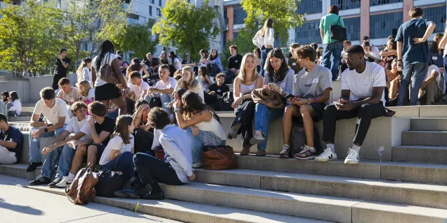 Étudiants sur les gradins du campus emlyon, participant à la vie étudiante et aux échanges de rentrée dans un environnement universitaire moderne.