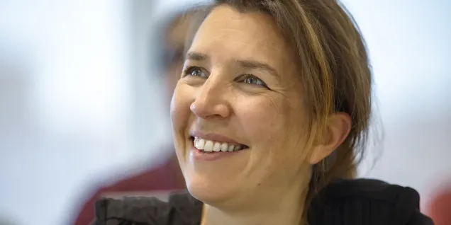 Portrait en gros plan d’une personne dans un environnement professionnel, regard tourné vers le haut, avec arrière-plan flou de bureau.