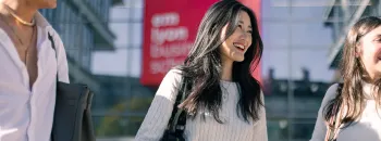 Des étudiantes et étudiants d'emlyon business school à l'entrée de l'École