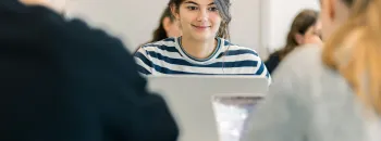 Étudiantes et étudiants du Programme Grande École (Master in Management) d’emlyon, assis en salle de cours et travaillant sur des ordinateurs portables.
