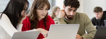 Étudiants collaborant sur des ordinateurs portables pendant un cours dans une école de commerce. Afficher plus de lignes