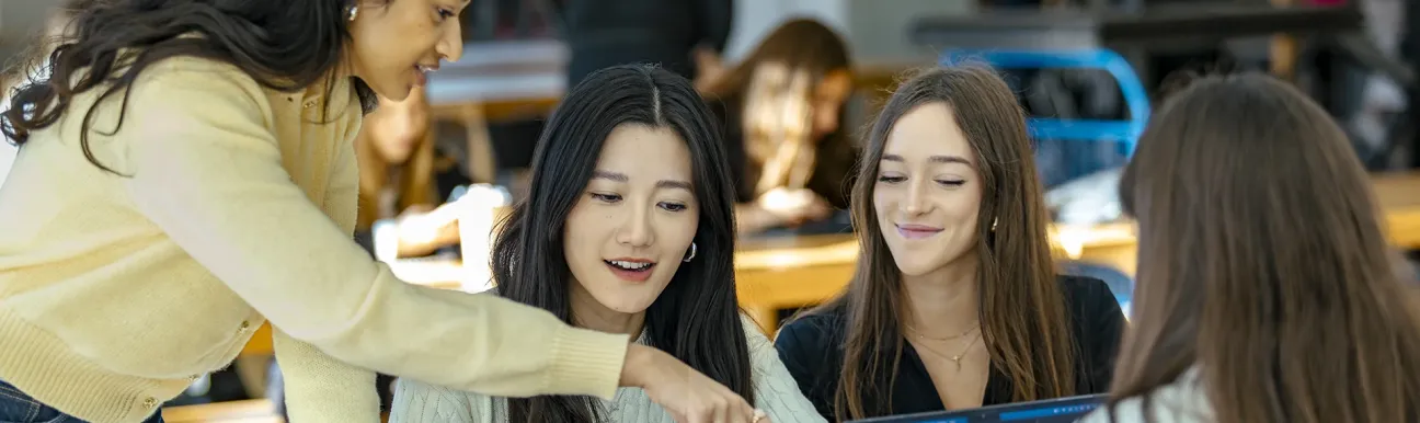 Groupe de personnes travaillant ensemble autour d’ordinateurs portables dans un environnement d’apprentissage ou de travail collaboratif.