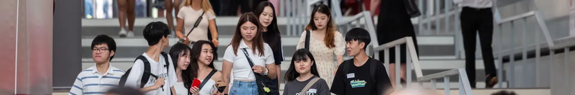 Des étudiantes et étudiants sur les escaliers de l'entrée sur Jean Jaurès, campus de Lyon - emlyon business school