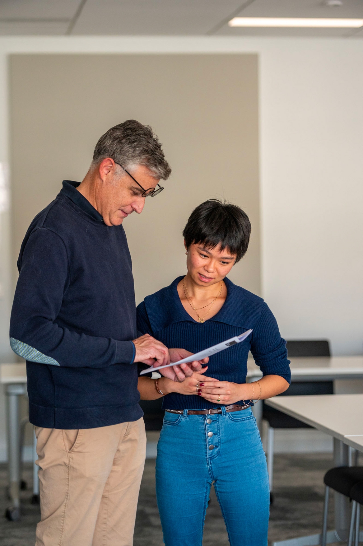 Un enseignant en train de consulter les notes d’une étudiante.