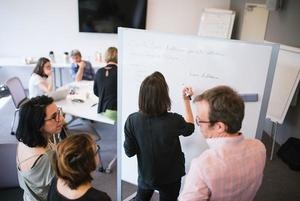 Groupe de travail autour d'un tableau de blanc 