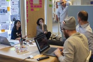 Cinq personnes en train de réaliser un brainstorming autour d'une table